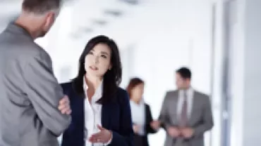 Business professionals engaged in conversation in a modern office setting.